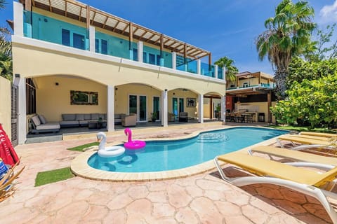 This stunning property features a sparkling pool with fun inflatables, sun loungers for soaking up rays, and spacious covered outdoor living areas perfect for relaxation and gathering.