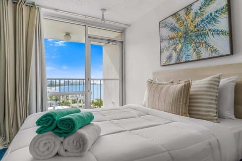airy bedroom retreat with comfortable bedding, vibrant accents, and private balcony access