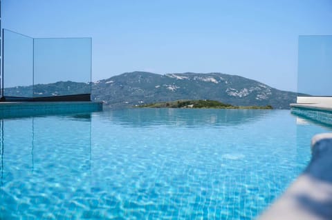 Infinity-Style Pool with Mountain Views – Stunning blue pool overlooking the natural green hills, offering complete peace and privacy.