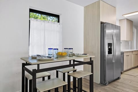 Bright and modern dining nook featuring a sleek high-top table beside the kitchen. Perfect for casual meals, morning coffee, or gathering with friends in a cozy, sunlit space overlooking the outdoors.