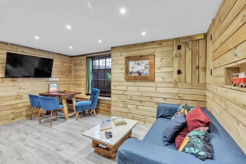 Bright, open-plan seating and kitchen area with urban log-cabin style wood accents and Scandinavian decor.