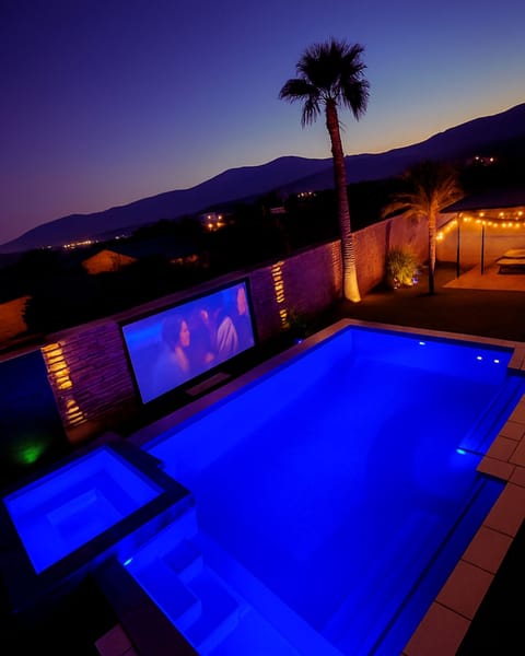 The perfect evening: the mountains fade into twilight, the pool lights up in blue, and your favorite movie plays under the open sky. Pure desert bliss.