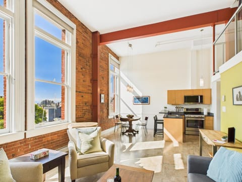 Expansive 800-square-foot open-concept layout featuring towering ceilings and wide south-facing windows for maximum natural light.