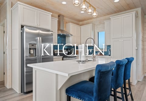 Modern kitchen with stainless appliances, spacious island, and seating for casual dining.