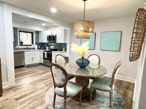 Gather around this beautiful glass-top table, featuring intricately detailed chairs with subtle seashell patterns for an authentic coastal feel.