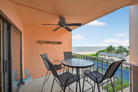 Outdoor balcony w/ dining set, ceiling fan, and relaxed seating for breezy meals or sunset chats.