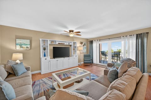 Bright living room w/ comfy sofas, coastal decor, and easy access to the balcony.