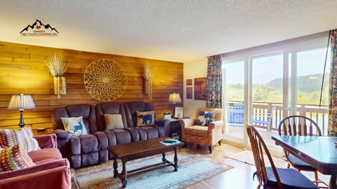 Open-concept living area with comfortable seating, game table, and easy access to the main deck. Designed for gathering, relaxing, and enjoying time together after mountain adventures.
