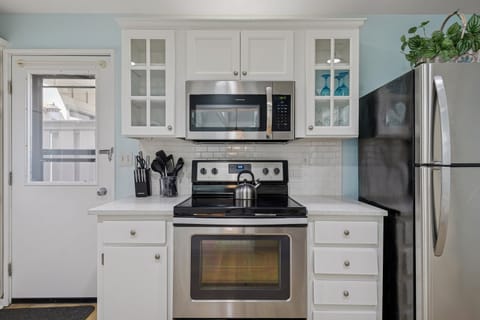 The updated kitchen is fully equipped with stainless steel appliances, granite countertops, and ample countertop space