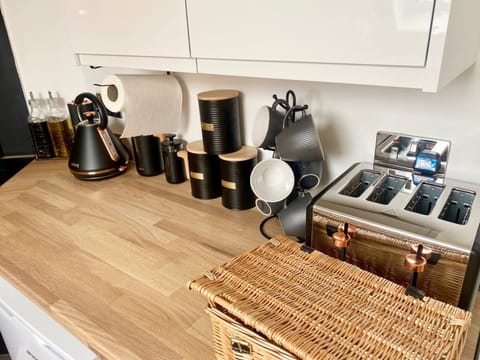 Fully equipped kitchen with modern appliances, including a sleek toaster, kettle, and coffee maker — ideal for lazy breakfasts or home-cooked meals.