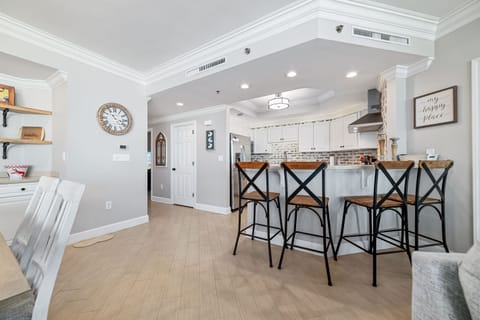 The modern kitchen island with bar seating offers a casual dining option, while the open layout maximizes natural light and showcases the stylish finishes throughout.