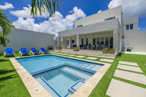 Covered terrace with cozy lounge seating and al fresco dining overlooking the pool.