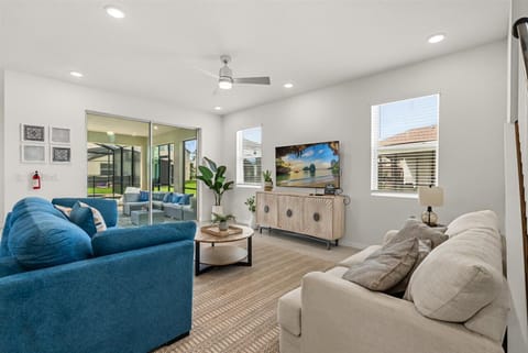 The living room invites you to unwind on cozy sofas, surrounded by fresh décor and bright natural light.
