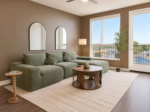 Spacious living room featuring a cozy L-shaped sofa, a full-size air mattress, and a 65" Smart TV with preloaded access to Netflix, Hulu, and Disney+, all set up for your enjoyment.
