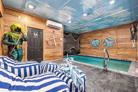 Indoor pool area with nautical-themed decor and striped lounge chairs.