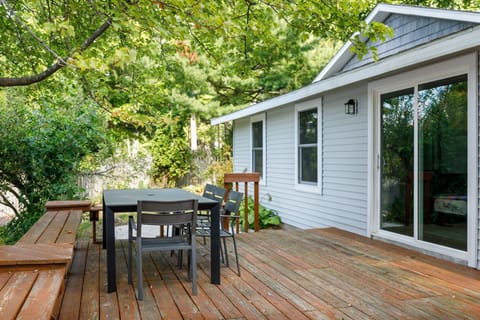 Relax on the spacious wooden deck w/ outdoor dining table, surrounded by leafy trees for a peaceful retreat
