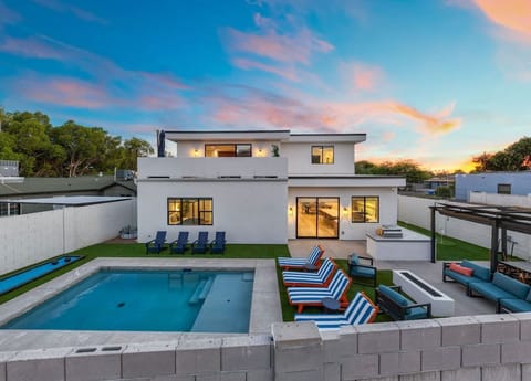 Twilight exterior—modern home and pool aglow for golden‑hour hangs.