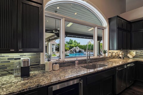 Enjoy peaceful views of the pool and waterfall from the oversized kitchen window while preparing meals in this elegant, light-filled space. Start your mornings right with our Keurig, drip coffee machine, and grinder for fresh coffee beans.