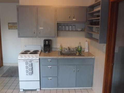 Full kitchen with refrigerator, stove, microwave, coffee makers, and most essentials