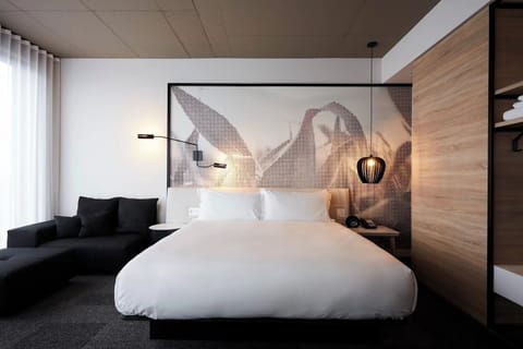 Unwind in crisp linens beneath bold, modern wall art.
