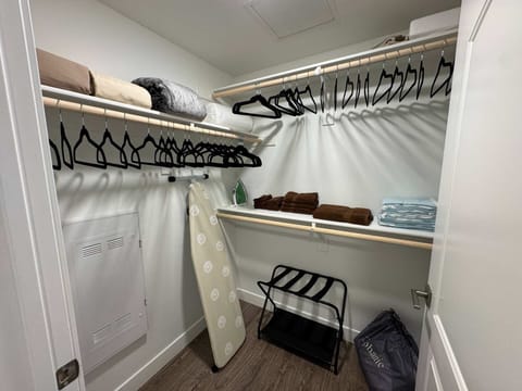 A spacious walk-in closet stocked with extra sheets, pillows, blankets, an iron, an ironing board, and a crib for your convenience.