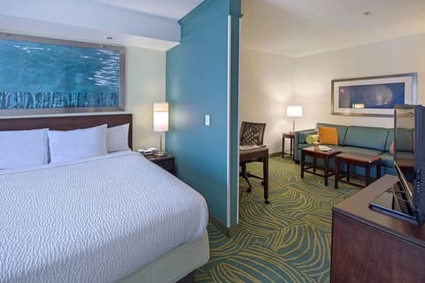 Unwind on crisp linens beside a cozy lounge corner.