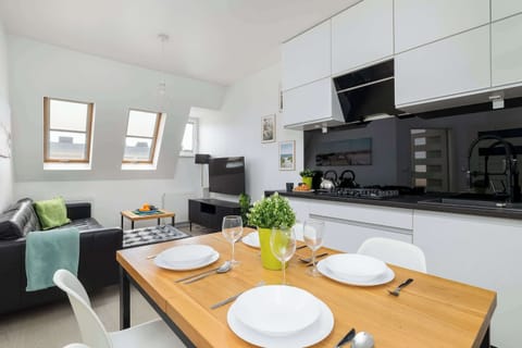 An inviting dining area, where a wooden table decorated with fresh flowers and modern place settings creates the perfect space to enjoy meals.