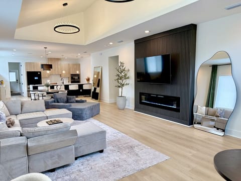 Cozy up in style with our sleek black accent wall featuring a mounted smart TV and modern electric fireplace—perfect for movie nights or just relaxing by the glow