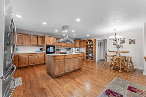 Kitchen | Expansive Space with Oak Cabinetry, Center Island & Stainless Steel Appliances