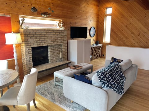 Living room with cozy fireplace, smart TV, and dining table