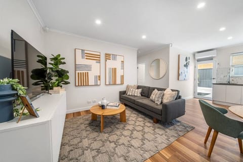 Unwind in the light-filled living area, where soft textures and warm timber tones set the pace for slow evenings in.