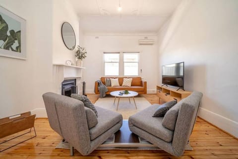 Stretch out in the living room where timber floors, high ceilings, and an ornate decorative fireplace give the space its classic bungalow charm.