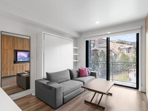 Studio living area with queen Murphy bed and balcony