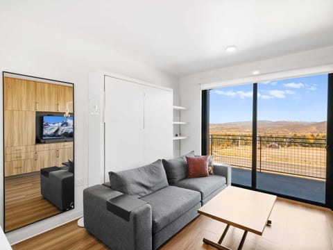 Studio living area with queen Murphy bed and balcony