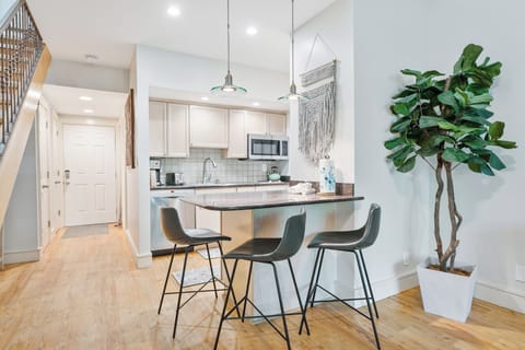 Modern kitchen with breakfast bar seating, stainless steel appliances, and stylish finishes.