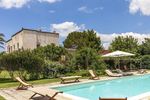 The pool, gardens and the imposing façade of Villa Elia rising behind.