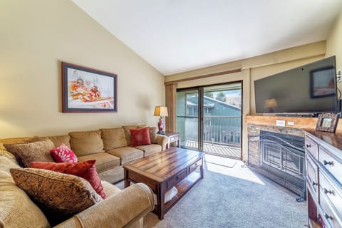 Bright open living room w/ TV and gas fireplace.