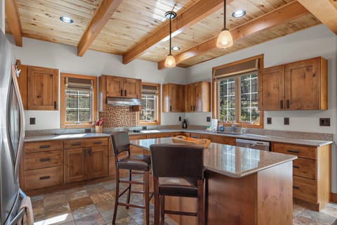 Spacious kitchen - offers tons of counter space, a walk-in pantry, stainless steel appliances, walk-out access to the back porch and propane barbecue grill, and hightop seating for two at the kitchen island.