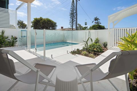 Relax by the pool with comfortable seating and a sunny outdoor setting.