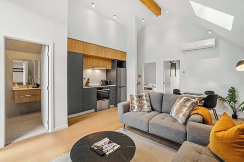 Modern open-plan living with high ceilings and skylight