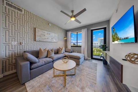 Modern Living Room with Balcony View-Bright and stylish living space featuring a plush sectional sofa, flat-screen TV, and chic décor. Enjoy natural light and city views from the balcony, perfect for relaxing or entertaining.