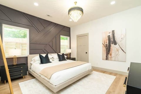 Master Bedroom with King Bed/walk in closet. 65 inch Roku TV with modern decor and accent wall.