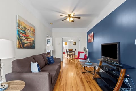 Relax in this bright living area featuring hardwood floors, a comfortable sofa, and a flat-screen TV. Perfect for unwinding after a day of exploring.