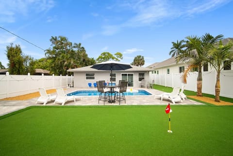 Pool in the backyard featuring a putting green
