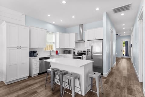 Modern kitchen with bar seating and stainless steel appliances.