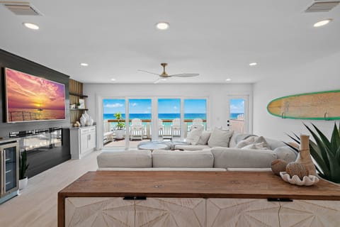 Living Room features Gulf Views through HUGE Sliding Door, a 65" Smart TV, comfortable seating, Wet Bar, Electric Fireplace, and Comfortable Seating - Come and Relax!