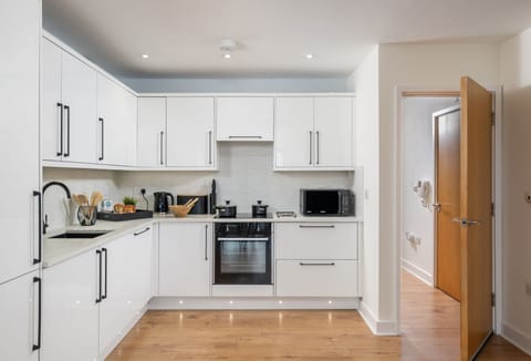 12 Ocean One, Newquay: Kitchen with an electric oven, induction hob, microwave, fridge/freezer, coffee machine and dishwasher
