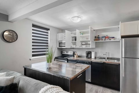 Cook and dine in our fully equipped kitchen! Features a spacious island, modern appliances including a stove, oven, microwave, and fridge. Stocked with essentials, coffee maker, and ample storage. Stylish blinds and a clock complete this functional space