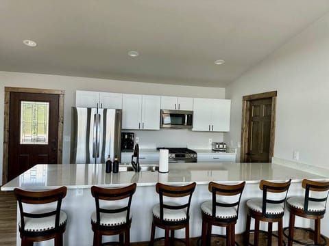 Fully stocked kitchen with 6 counter height stools for eating