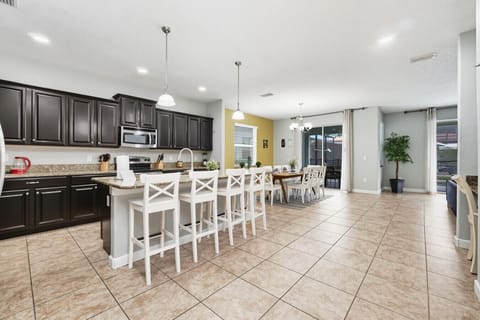 Open kitchen with island bar and dining area